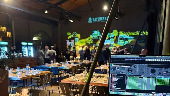 Festlich gedeckte Tischreihen im Altes Mädchen in Hamburg, im Vordergrund der DJ-Controller
