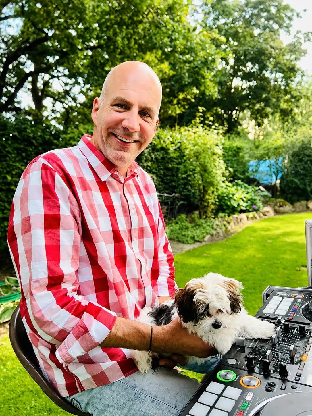 Patrick Miles mit seiner Havaneser-Hündin Gigi am Controller im Garten
